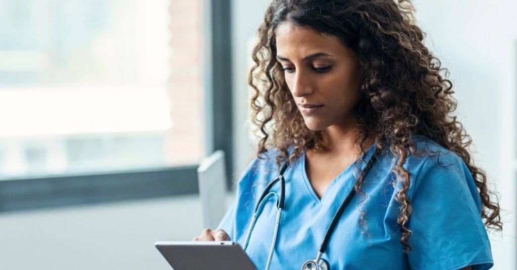 female doctor reviewing notes on a tablet