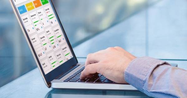 typing on a laptop, showing graphs