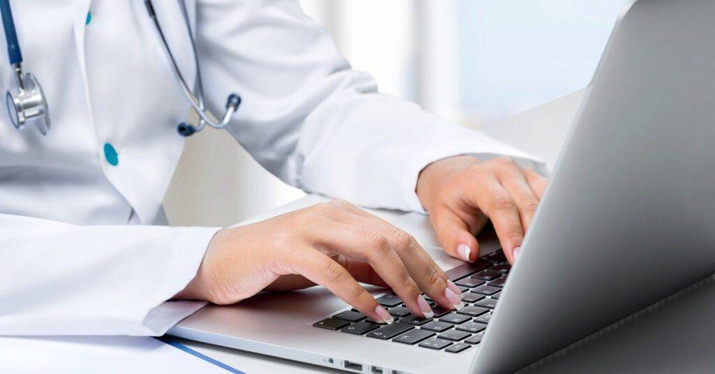female doctor using a computer to update EHR