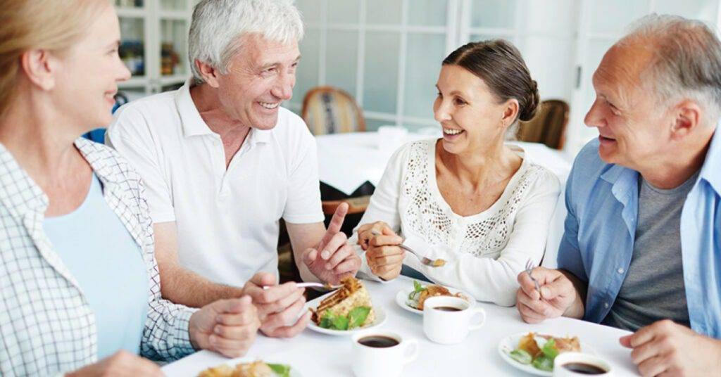happy patients at a life plan community eating dinner