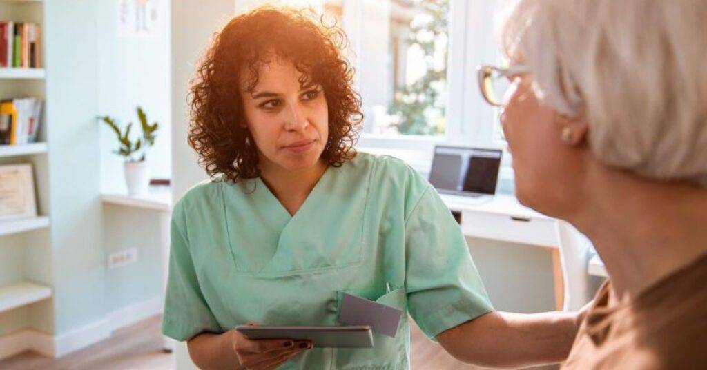 healthcare professional chatting with Elderly patient