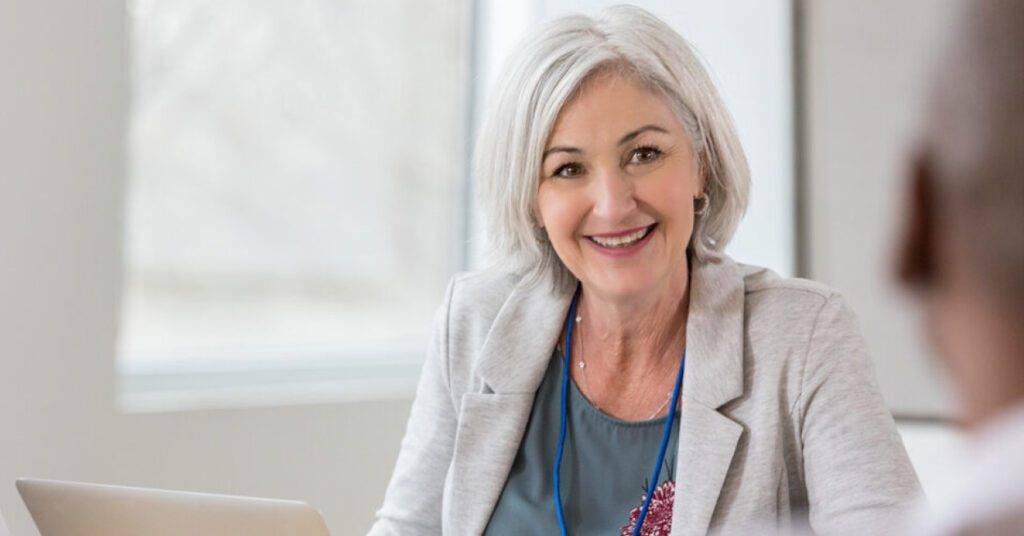 woman with gray hair in gray blazer