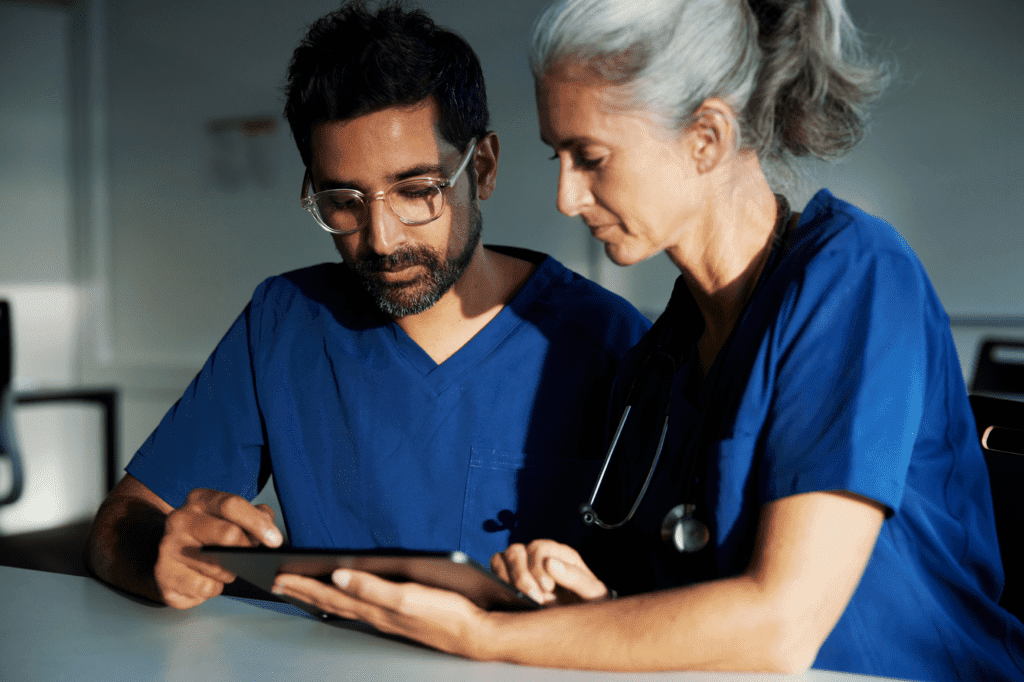 two long-term health care professionals look at tablet